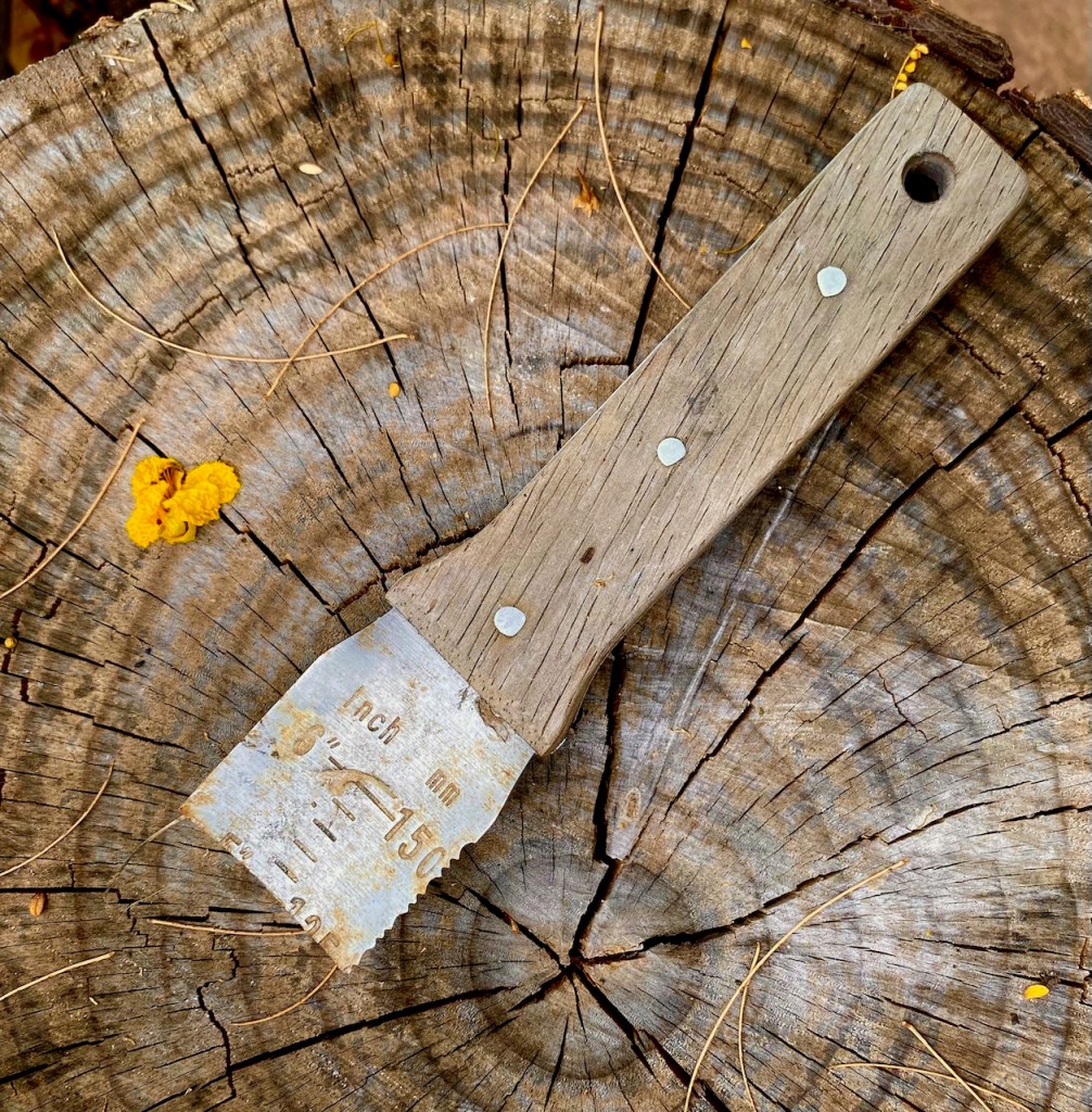 A broken hori hori knife with ruler etched into what remains of the blade.